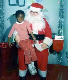 African american girl sitting on santa's lap