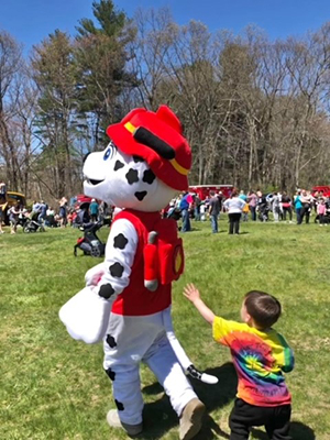 Child chasing person dressed as a Paw Patrol character
