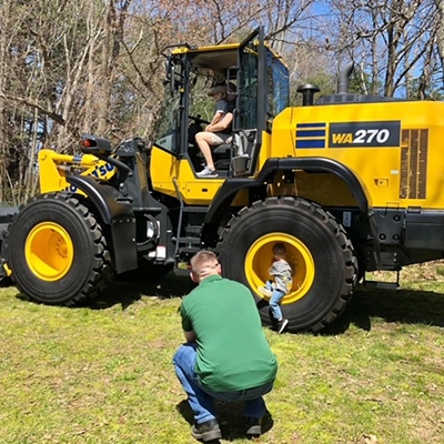 Child sitting inside of a tractor wheel