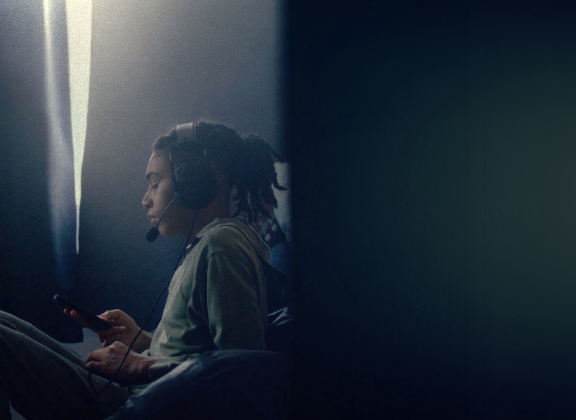 image of teenage boy on his phone with headphones on