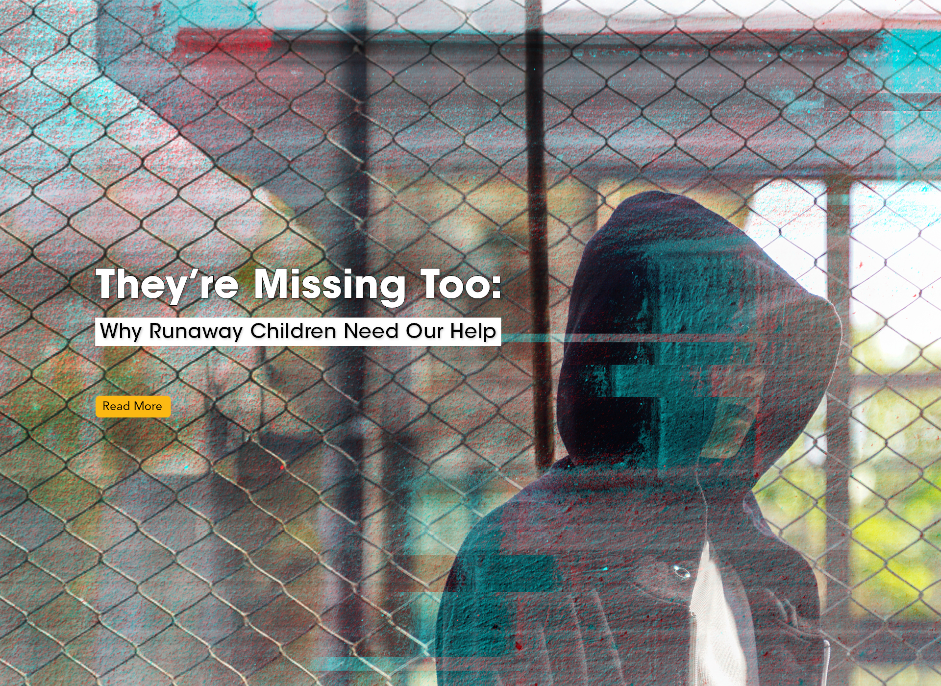 hooded teen behind a chain link fence