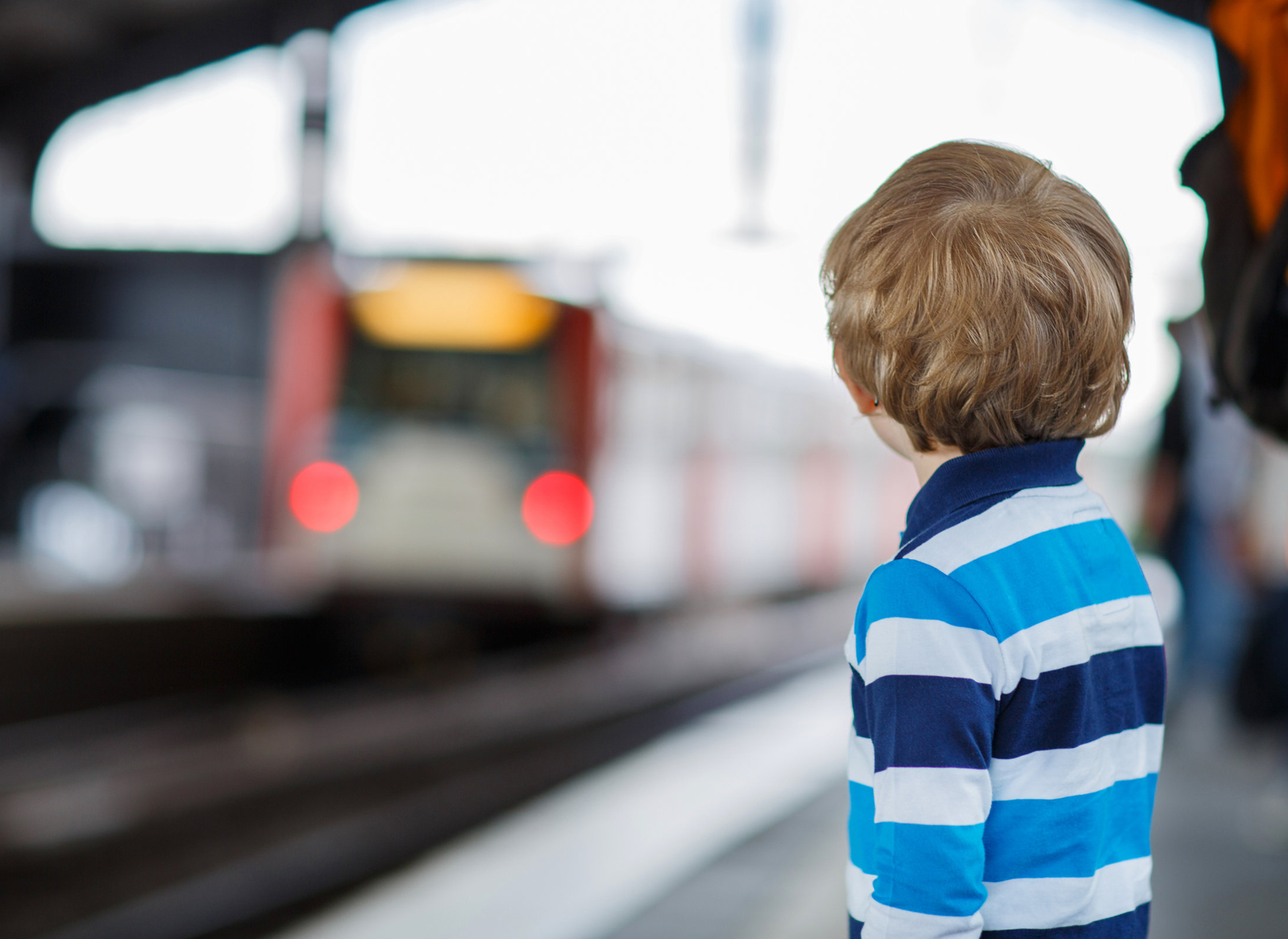 Little boy watching a moving train