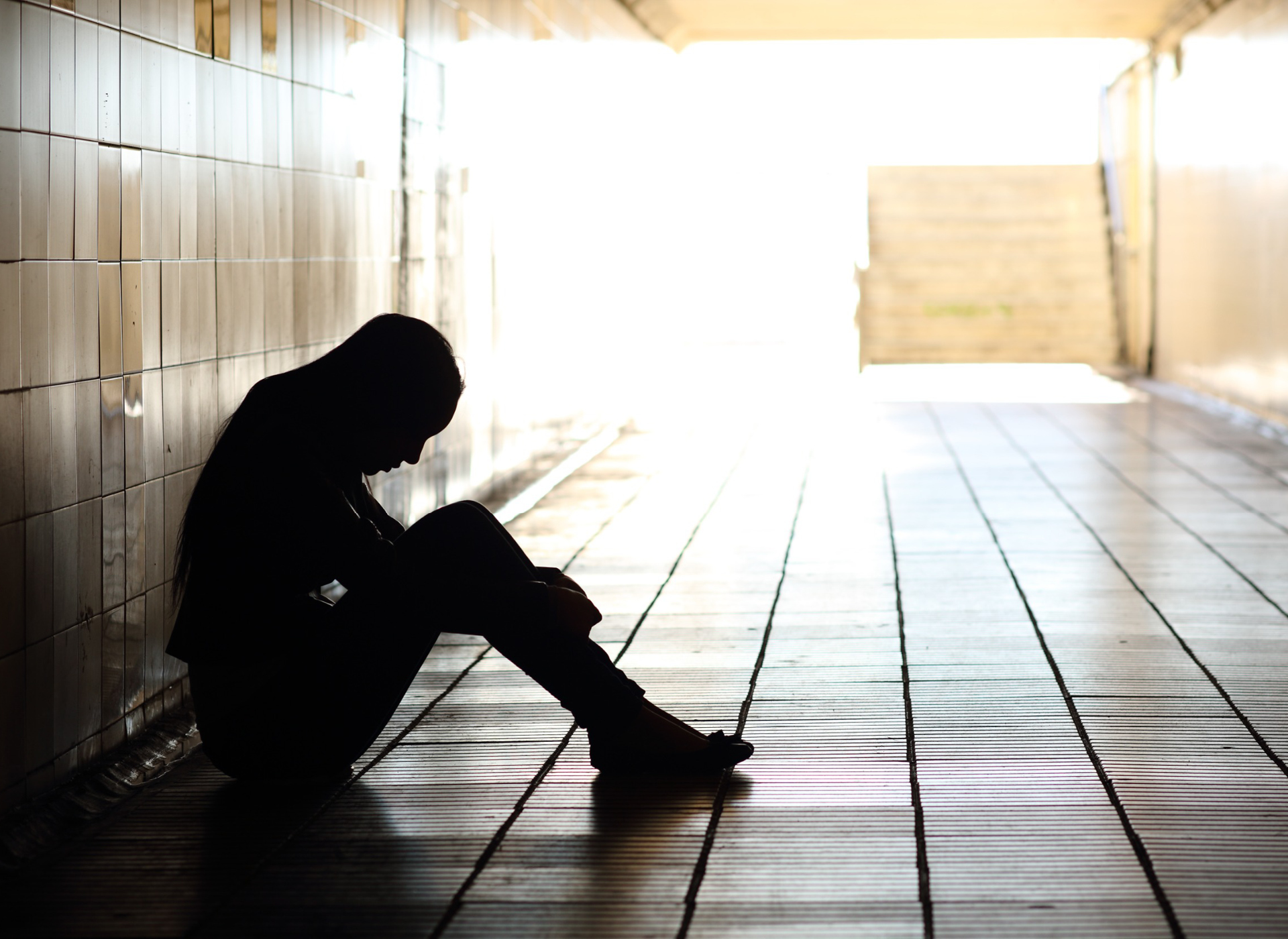 Silloutte of teen sitting on the floor