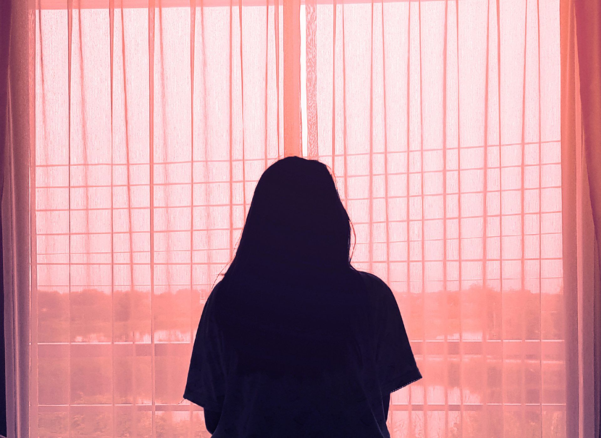 Silhouette of woman in front of window