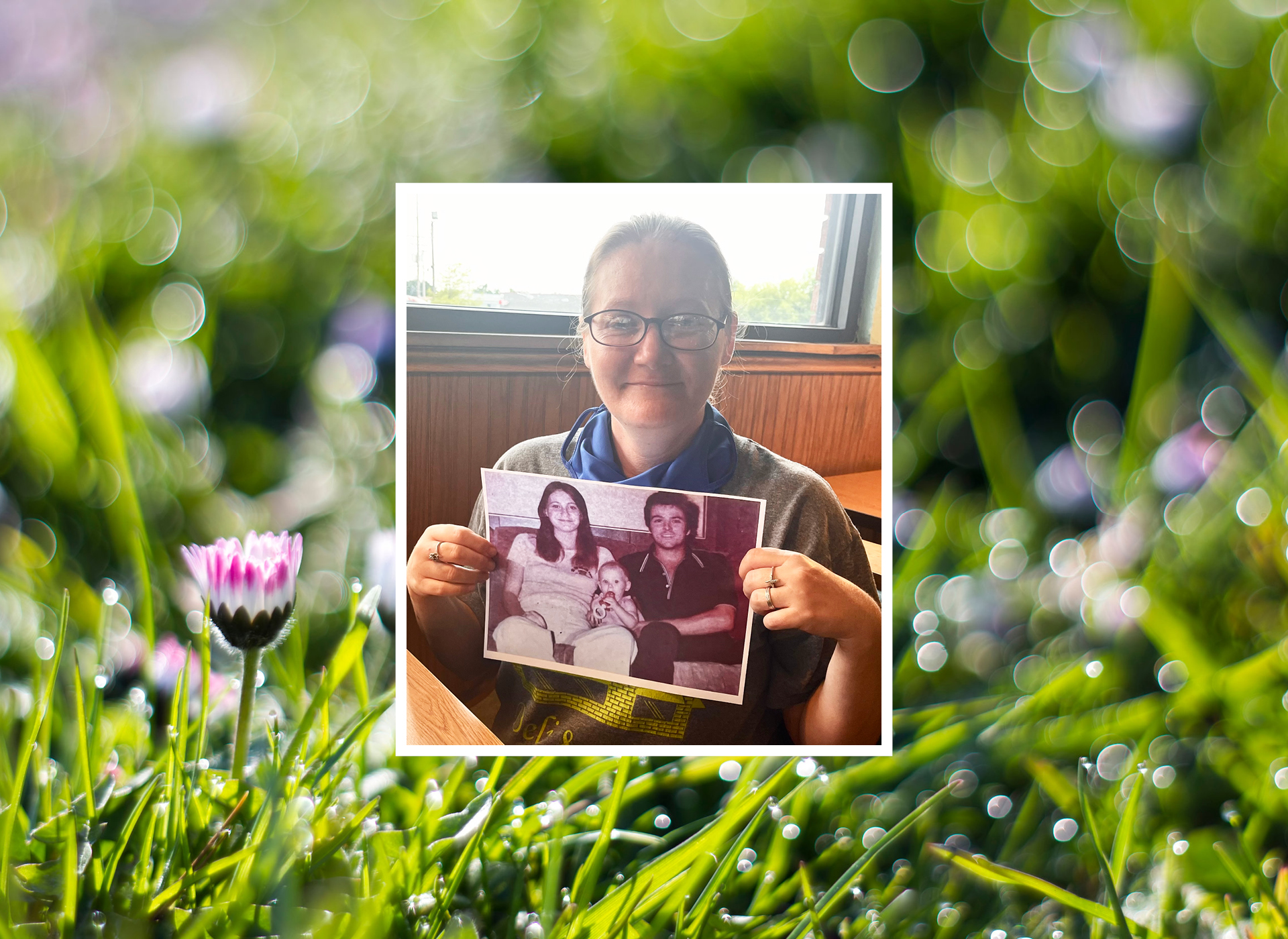 Lady holding up picture of 2 parents and a baby