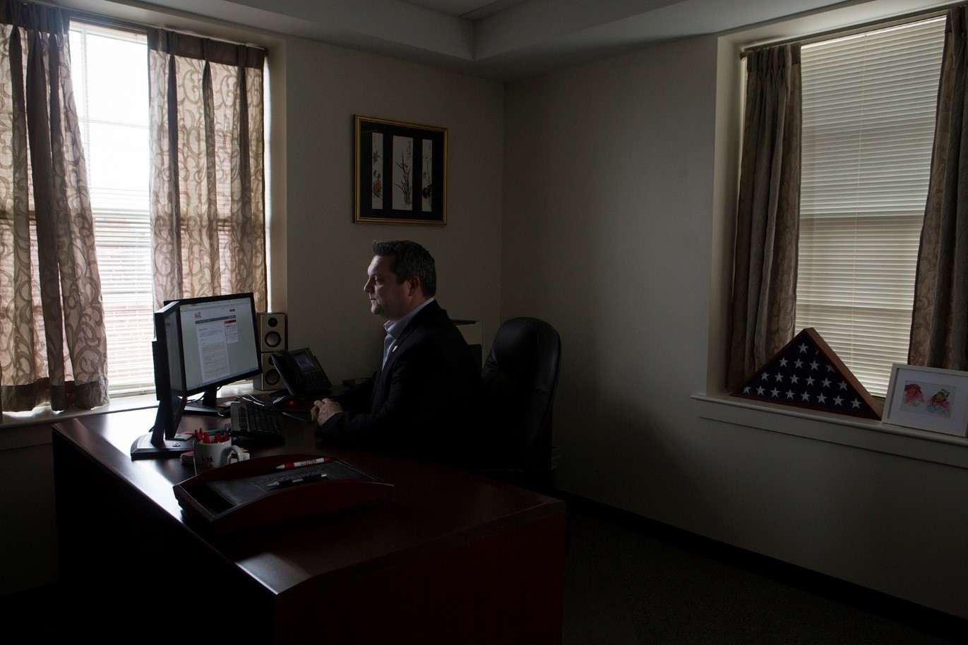 Caucasian man in dark office at laptop