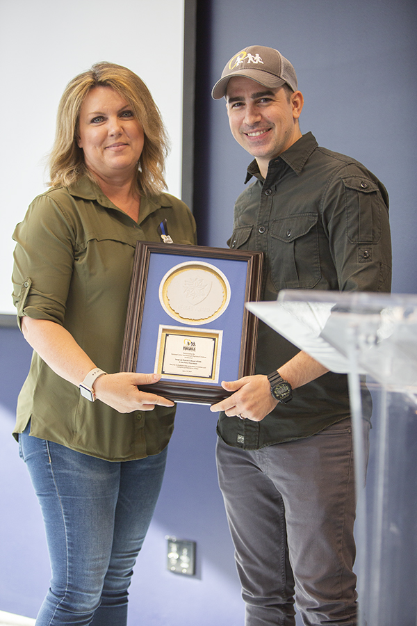 woman accepts award from man