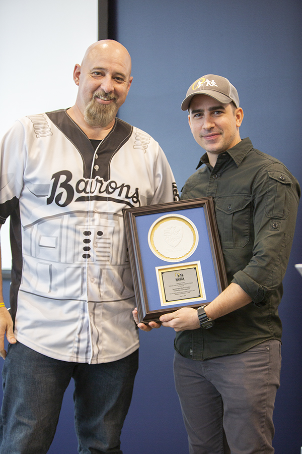 man accepts award from man
