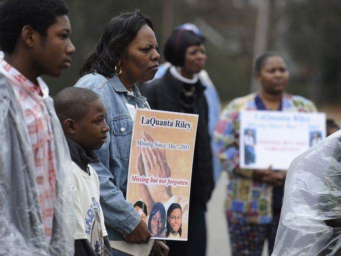 African American men and women holding signs to find missing kids
