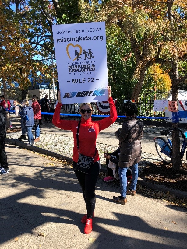 woman in red holding sign for marathon